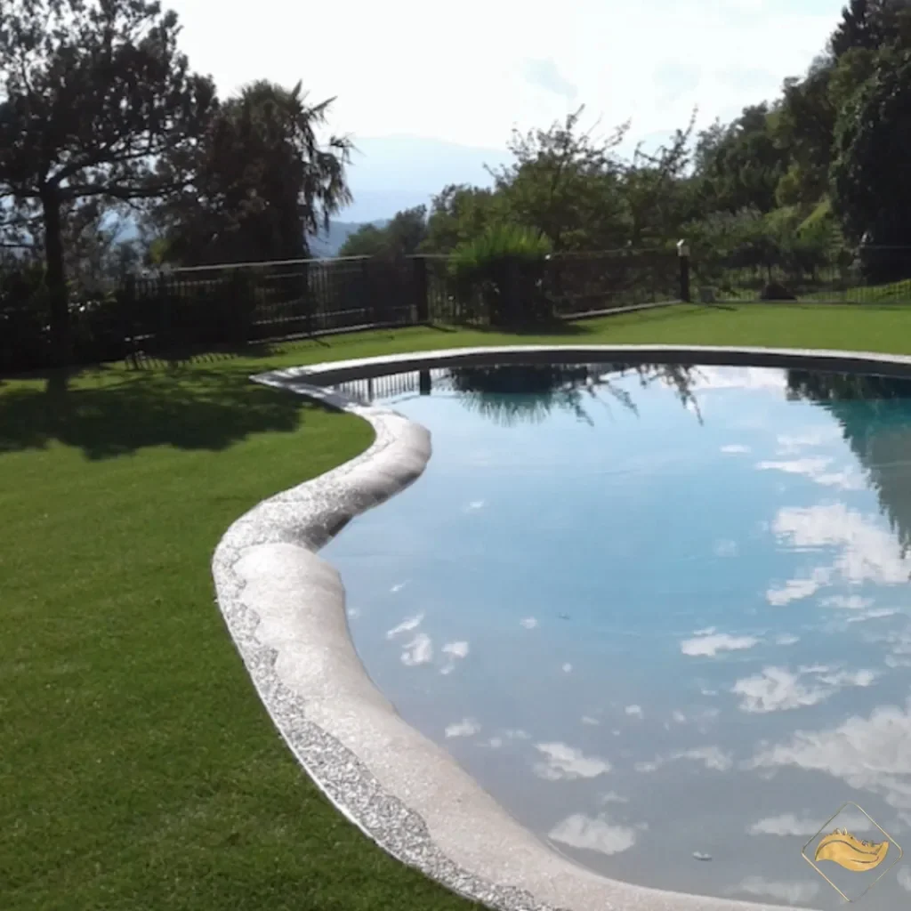 Piscina circondata da erba sintetica, perfetta per un ambiente elegante, drenante e senza manutenzione.